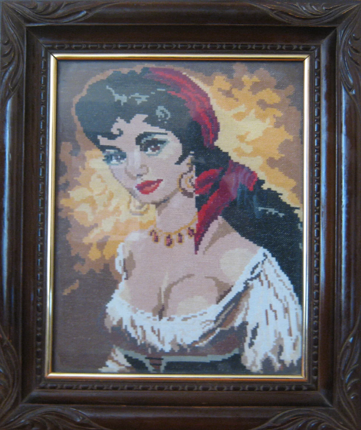 Dark-haired woman with a red headscarf and white blouse in a carved dark frame