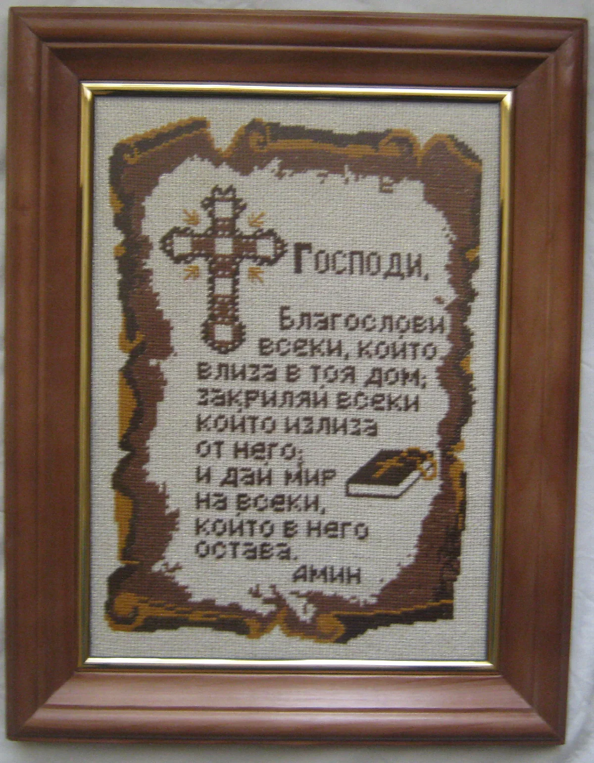 Stitched household blessing with a cross and book inside a brown frame