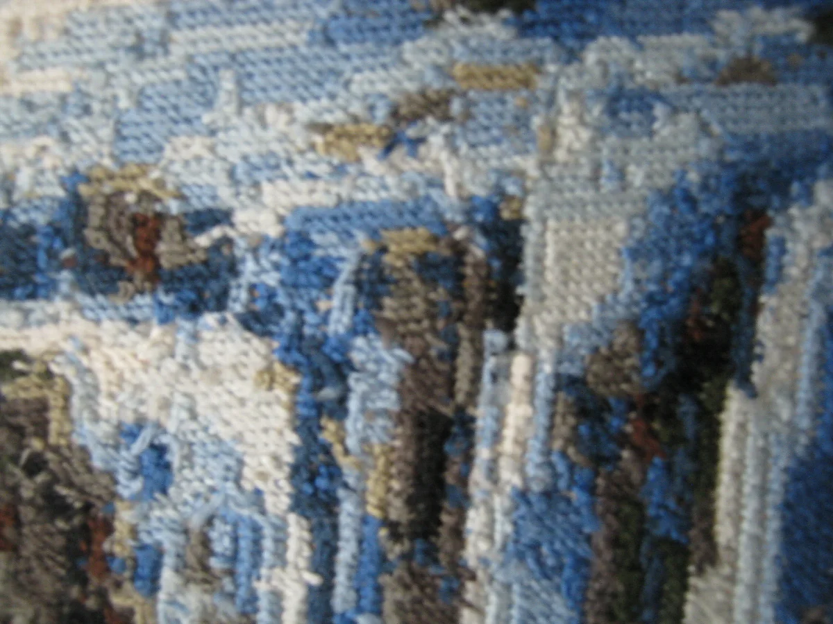 Reverse thread detail of pale blue falling water beside dark vertical rock shapes
